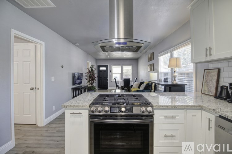 A modern kitchen with a stove top oven and a range hood.