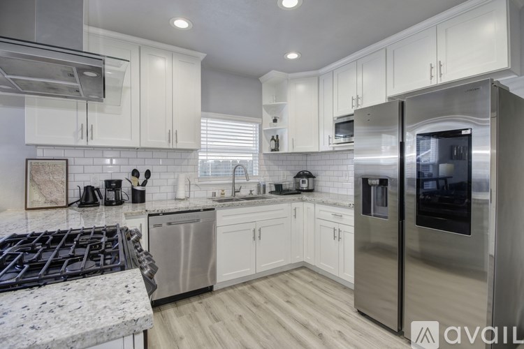 A modern kitchen with stainless steel appliances and white cabinets.