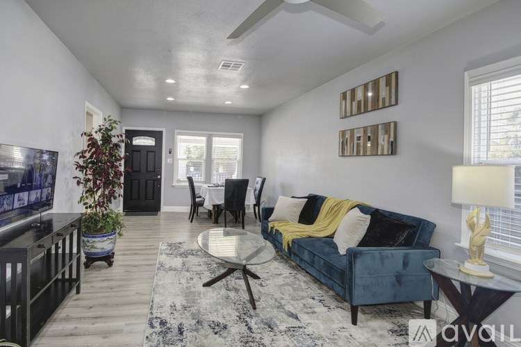 A living room with a blue couch and a rug.