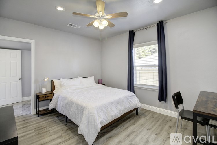 A bedroom with a bed, chair, and table.