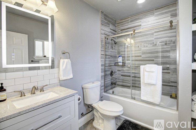 A bathroom with a white toilet, sink, and a mirror.