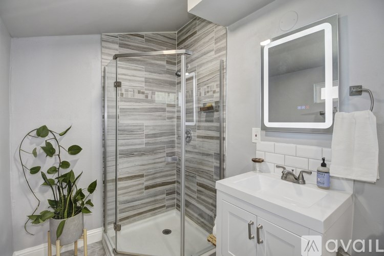 A bathroom with a glass shower stall and a white sink.