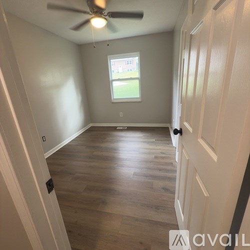 A kitchen with a black microwave, white cabinets, and a wooden countertop.