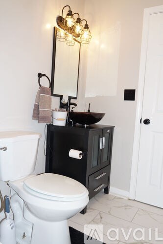 A white toilet sits next to a sink in a bathroom.