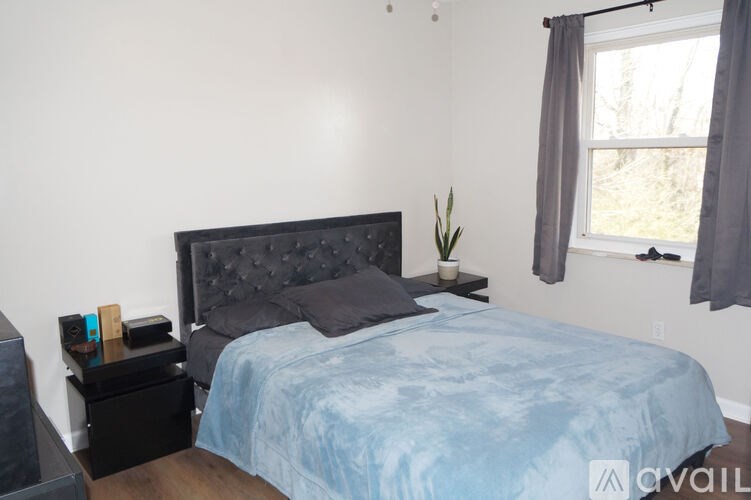A bedroom with a blue bedspread and a black headboard.