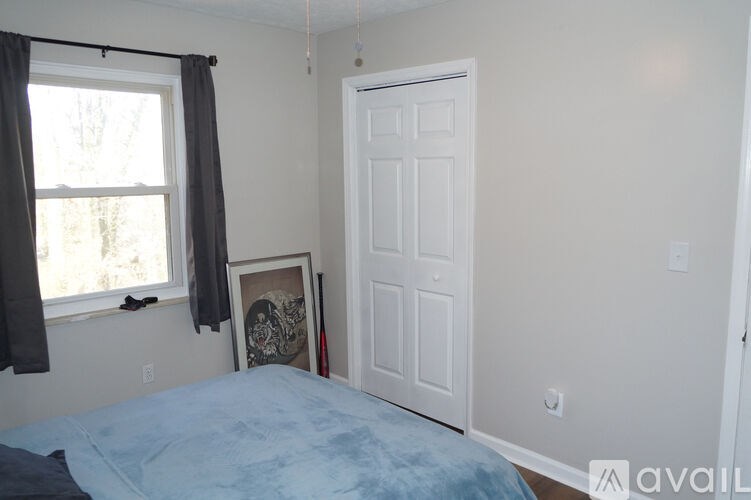 A bedroom with a bed, window, and a door.
