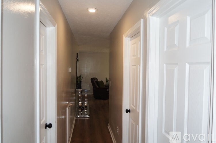 A hallway with white doors and a brown floor.