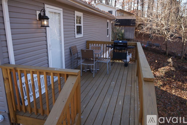 A small house with a deck and a grill.