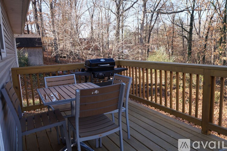 A wooden deck with a grill and chairs.