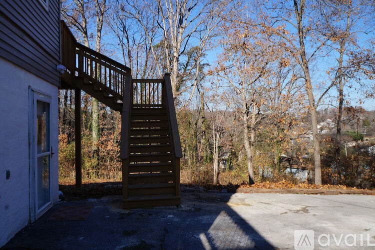 A wooden staircase leads up to a building with a white door.
