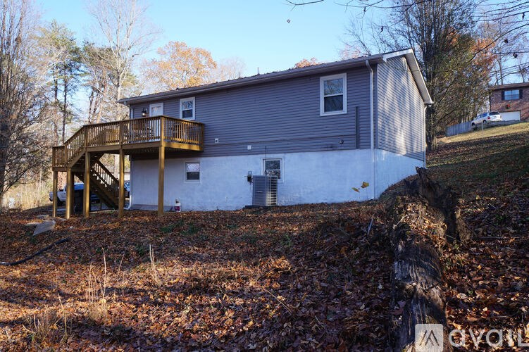 A house with a grey roof and a white wall with a balcony.