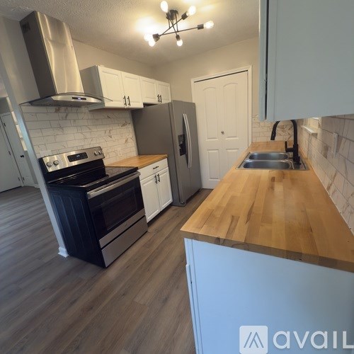 A house with a garage is surrounded by trees.