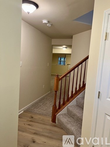 A hallway with a staircase leading to a second floor.