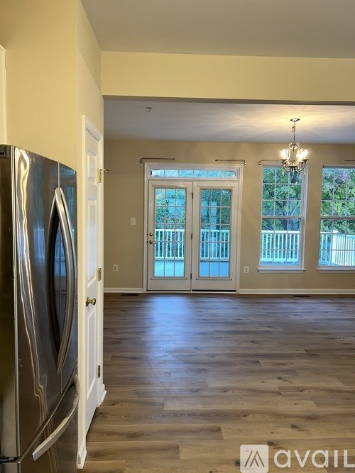 A kitchen with a refrigerator and a chandelier.