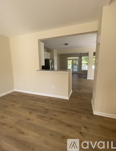 A room with wooden flooring and a mirror on the wall.