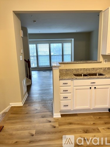 A kitchen with white cabinets and a granite countertop.