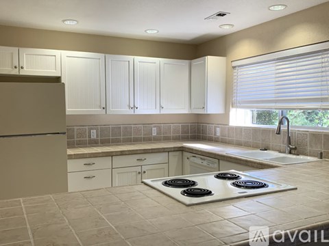 A kitchen with a stove top in the middle of the room.