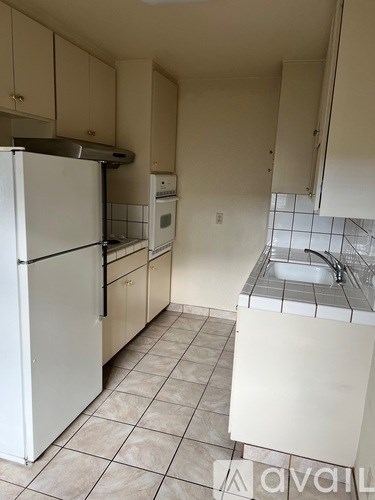 A kitchen with white appliances and a white sink.