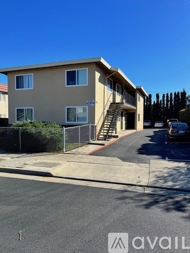 A beige building with a staircase leading to the entrance.