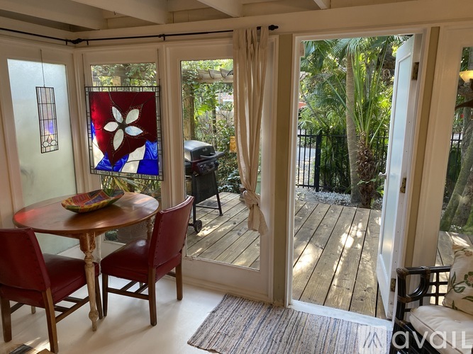 A table with chairs and a stained glass window in a room.