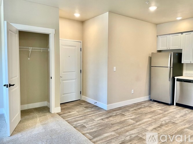 A room with a white door, a white cabinet, and a beige wall.