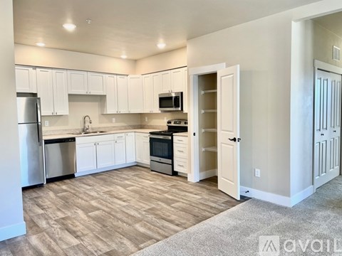 A kitchen with white cabinets and a refrigerator.