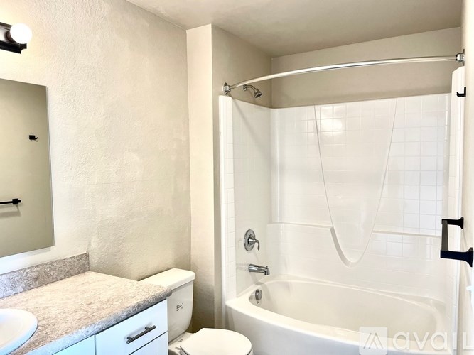 A white bathroom with a toilet, sink, and bathtub.