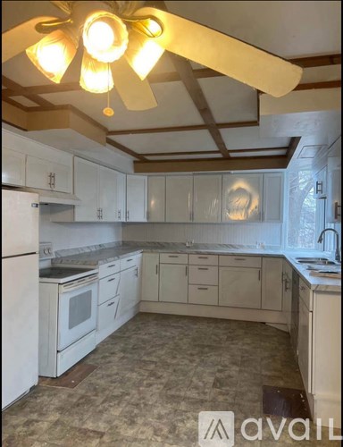 A kitchen with white appliances and cabinets.