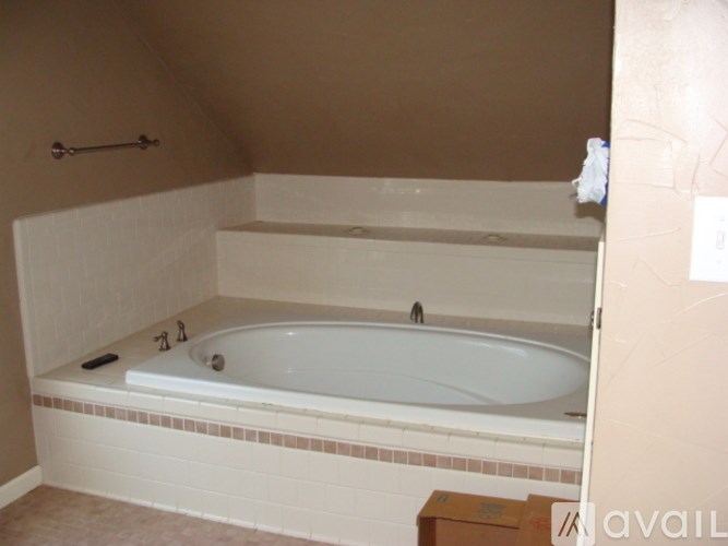 A white bathtub with a shower head and faucet.