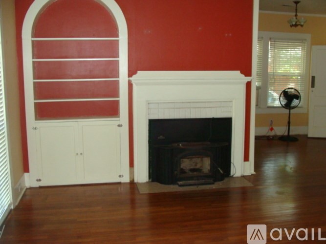 A fireplace with a white mantle and a wooden floor.