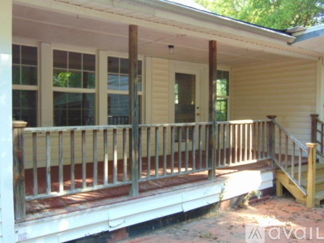 A porch with a white railing and a wooden staircase.
