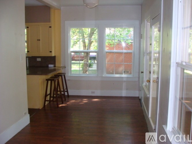 A kitchen with wooden floors and white walls.
