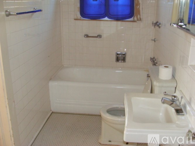 A white bathroom with a toilet, sink, and bathtub.