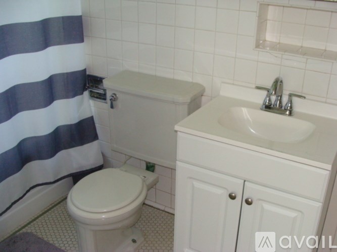 A white toilet sits next to a white sink in a bathroom.