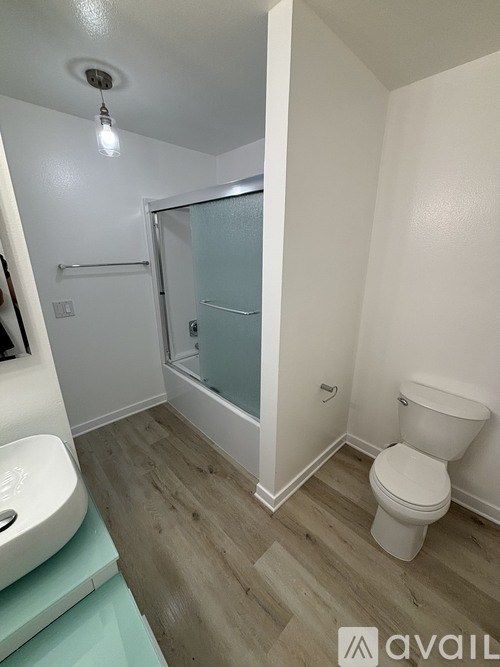 A bathroom with a toilet, sink, and shower.