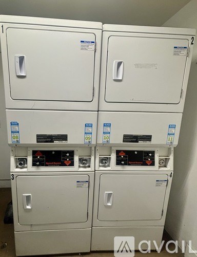 A stack of four white appliances with blue stickers on them.