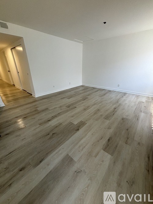 A room with wooden flooring and white walls.