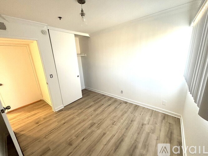 A room with wooden flooring and white walls.