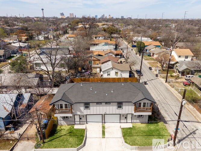 A house with a garage is in the foreground of a residential street.