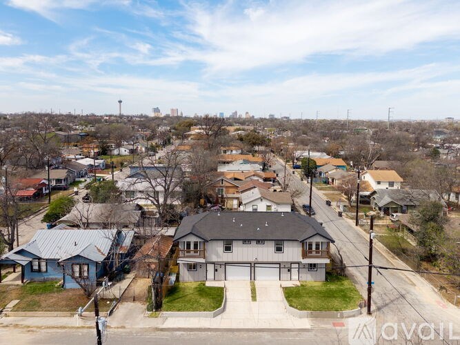 A house with a garage is in the foreground of a residential street.