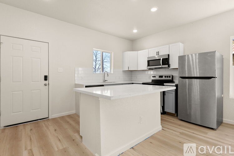 A kitchen with white cabinets and a stainless steel refrigerator.