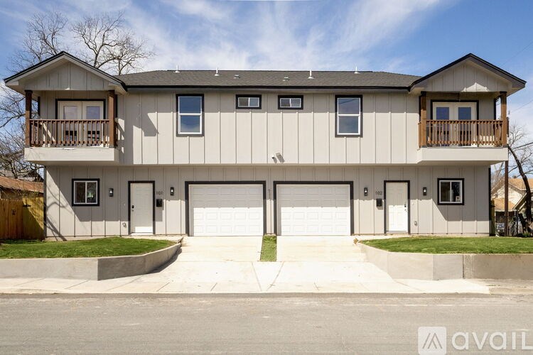 A two-story house with a balcony on the second floor.