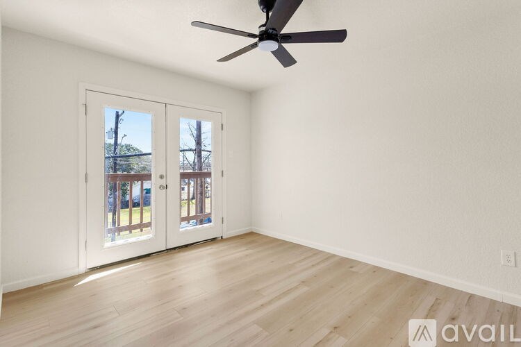 A room with a ceiling fan and wooden flooring.