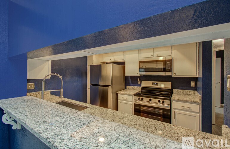 A kitchen with a granite countertop and stainless steel appliances.