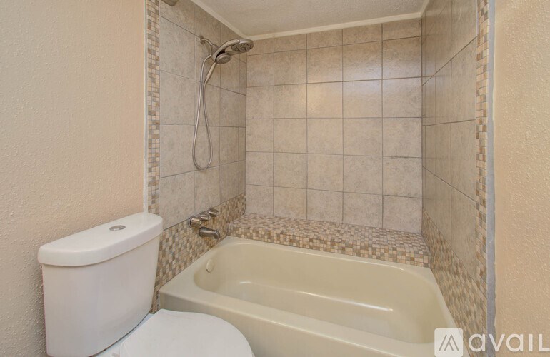 A white toilet sits next to a bathtub in a bathroom.