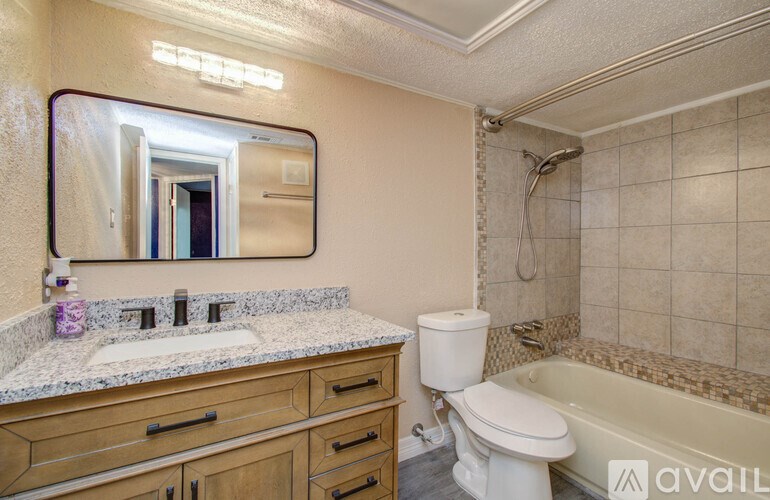 A bathroom with a sink, toilet, and bathtub.