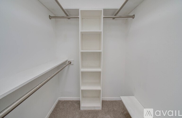 A white shelving unit in a room with a carpeted floor and white walls.