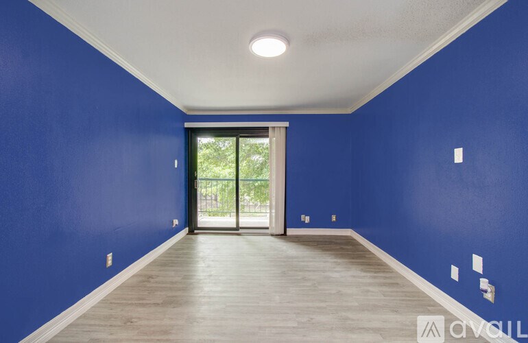 A room with blue walls and a sliding glass door leading outside.