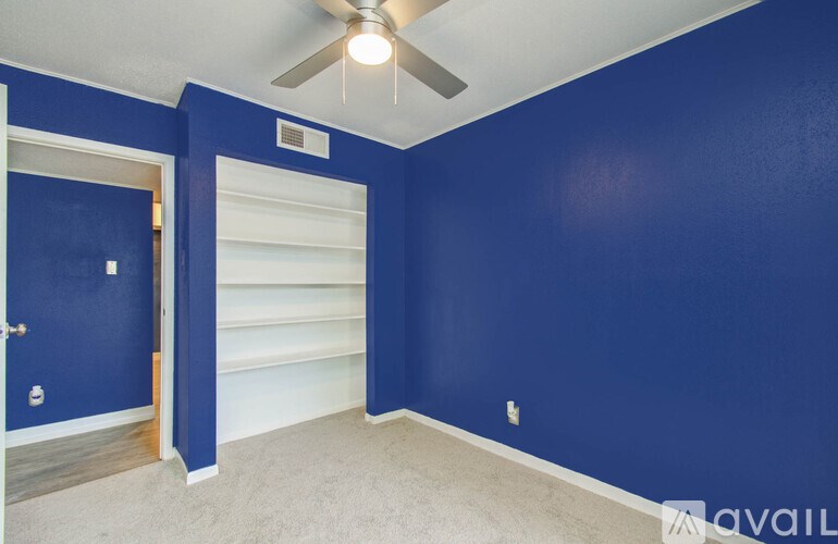 A room with blue walls and a ceiling fan.