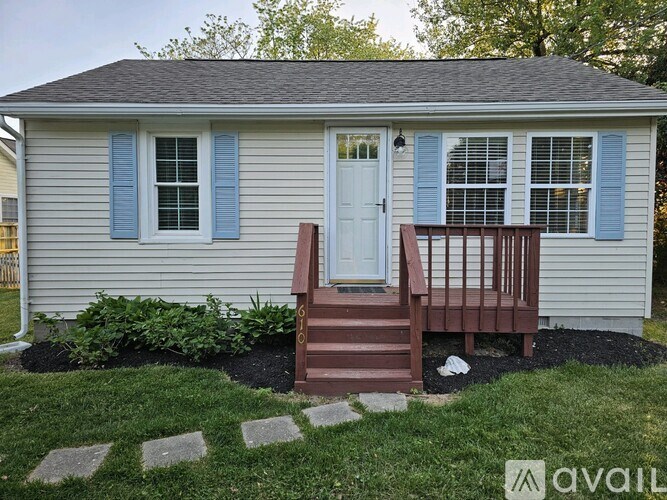 A small house with a white door and blue shutters.